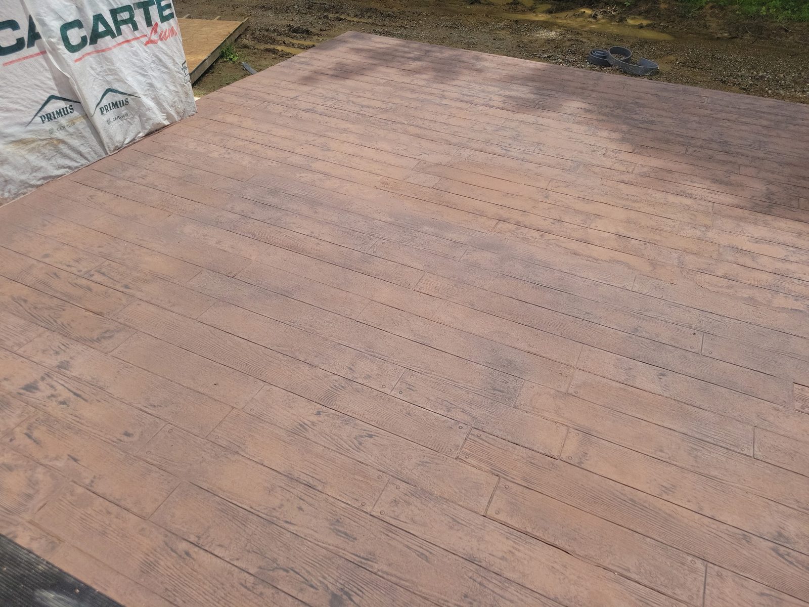 Wood-plank stamped concrete patio stained a rich reddish brown, poured by CS & Sons Concrete in Northeast Ohio